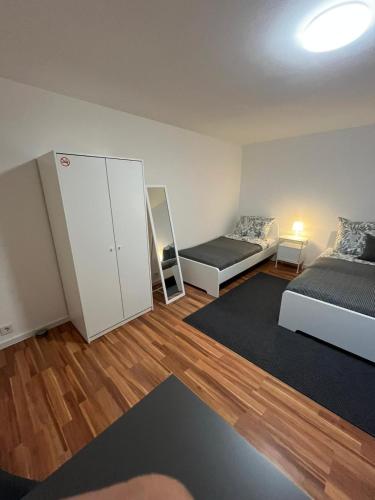 a small room with two beds and a closet at FlexStay Room 9 in Karlsruhe