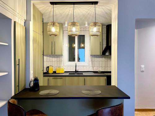 Charming Acropolis Flat with stunning Roof Terrace في أثينا: مطبخ مع طاولة مع كراسي وأضواء