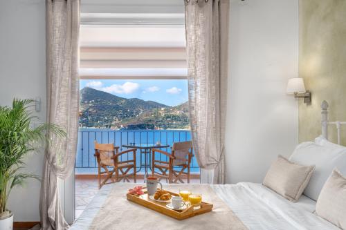 a bedroom with a bed and a table with a tray of food at Niovi Seaview Apartments in Áyioi Apóstoloi