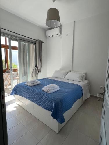 a bedroom with a bed with a blue comforter at Eftyhia's Cozy apartment Patmos in Skala