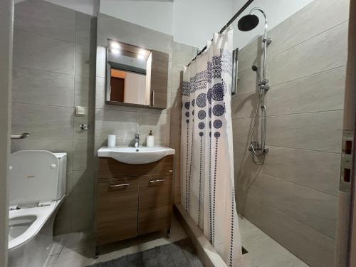 ein Badezimmer mit Waschbecken und Dusche in der Unterkunft Eftyhia's Cozy apartment Patmos in Skala