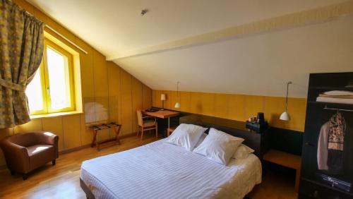 ロマン・シュル・イゼールにあるHôtel de charme L'Orée du Parcのベッドと椅子のあるホテルの部屋