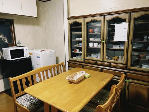 a table and chairs in a kitchen with a refrigerator at 直島古民家一棟貸し笑くんNaoshima 'Shoukun' Entire house in Naoshima