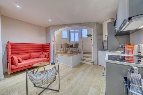 een woonkamer met een rode bank in een keuken bij La porte de Mars - Air conditioning in Reims