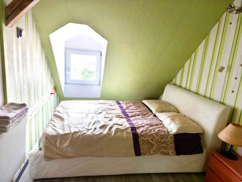 Posto letto in camera verde con finestra di Apartament Gościnne Gniazdo a Gliwice