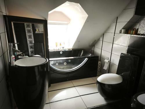 un bagno con vasca, lavandino e WC di Apartament Gościnne Gniazdo a Gliwice