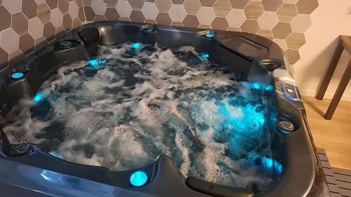 a jacuzzi tub with blue lights in it at L'Antre Du Désir in Wierre-Effroy