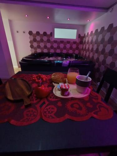 - une table avec une assiette de nourriture et une baignoire dans l'établissement L'Antre Du Désir, à Wierre-Effroy