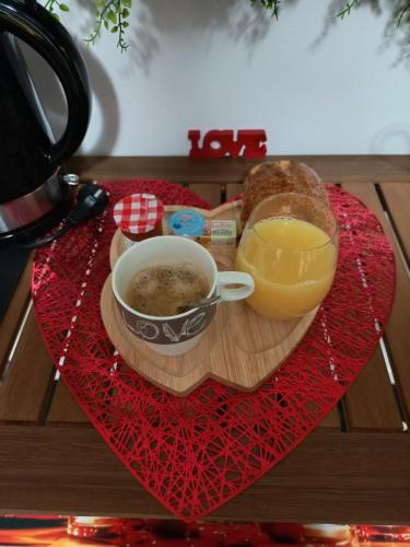 ヴィエール・エフロワにあるL'Antre Du Désirのコーヒーとオレンジジュースのグラス入りのトレイ