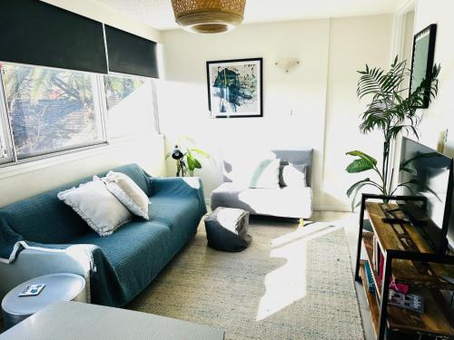 a living room with a blue couch and a tv at Paddington chic at Five Ways in Sydney