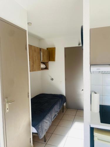 ein kleines Zimmer mit einem Bett und einer Küche in der Unterkunft Appartement in Lamalou-les-Bains