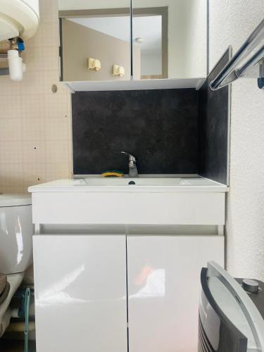 ein Badezimmer mit Waschbecken und Spiegel in der Unterkunft Appartement in Lamalou-les-Bains