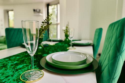 a green dining table with a plate and a glass at Cinema Lounge 2Bed Leeds City Centre FREE Parking in Leeds