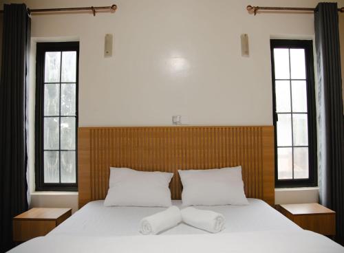 a bedroom with a large bed with two white pillows at Ecolux rebero residence in Kigali