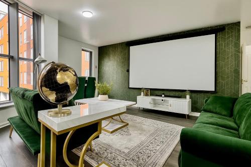 a living room with a green couch and a large screen at Cinema Lounge 2Bed Leeds City Centre FREE Parking in Leeds