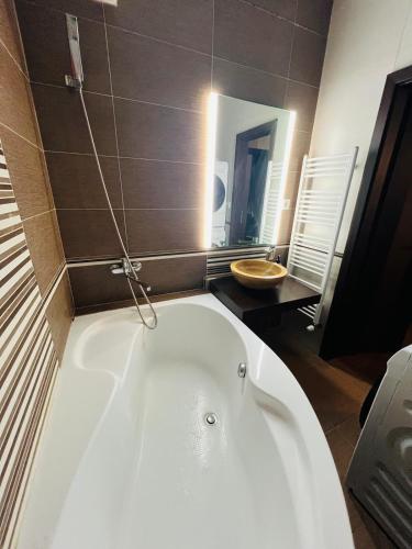 a white bath tub in a bathroom with a mirror at Zilina Sweet Escape in Žilina