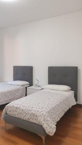 two beds in a room with white walls at I Giardini Magenta in Magenta