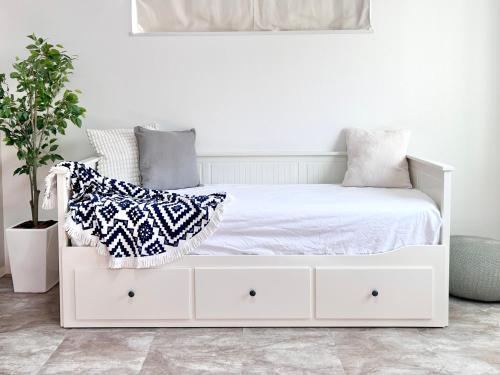 隠れ宿 藤 Private Inn Fuji - 足利駅5分の一棟貸切のお宿 في أشيكاغا: غرفة نوم بيضاء مع سرير أبيض عليه وسائد