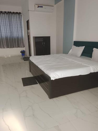 a bedroom with a large bed in a room at Hotel Krishna Rooms in Jāmb