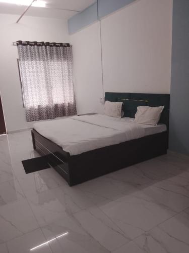 a bedroom with a large bed with a window at Hotel Krishna Rooms in Jāmb