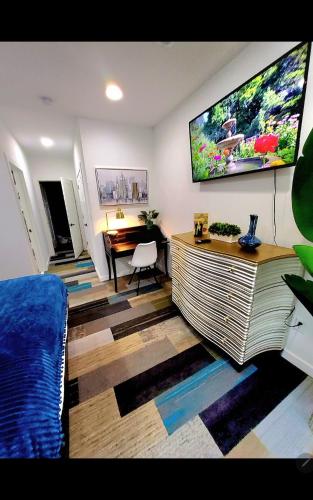 a room with a bed and a tv on a wall at Fountain Square Dream Dwelling - Sleeps 8, Near Downtown, Stadiums & Nightlife in Indianapolis