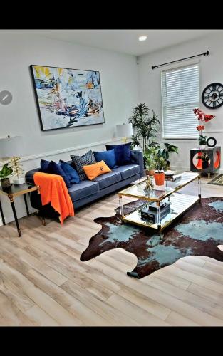 a living room with a blue couch and a table at Fountain Square Dream Dwelling - Sleeps 8, Near Downtown, Stadiums & Nightlife in Indianapolis
