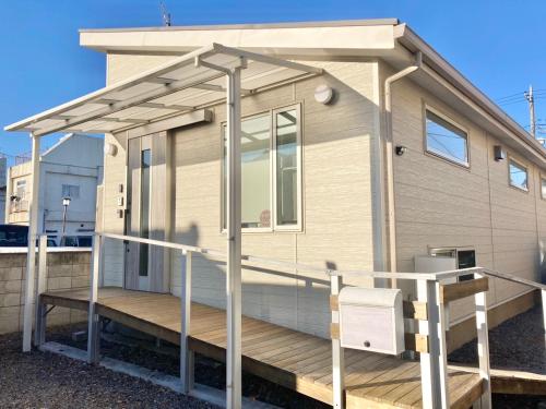 a tiny house with a porch and a deck at 隠れ宿 藤 Private Inn Fuji - 足利駅5分の一棟貸切のお宿 in Ashikaga