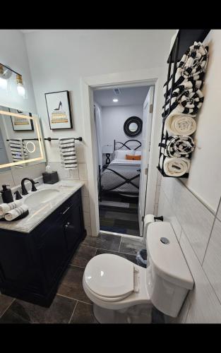 a bathroom with a toilet and a sink and a bed at Fountain Square Dream Dwelling - Sleeps 8, Near Downtown, Stadiums & Nightlife in Indianapolis