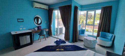 The Bedroom Kata Beach Phuket في شاطئ كاتا: غرفة زرقاء مع سرير ومكتب ومرآة