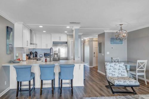 a kitchen with blue bar stools and a counter at Wellness Retreat - Oceanfront condo w beach access in Ponte Vedra Beach