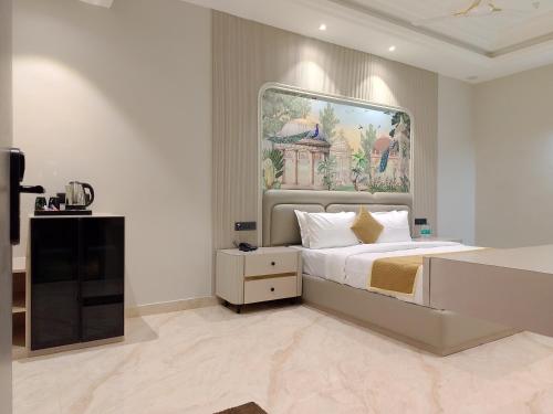 a bedroom with a bed and a painting on the wall at JBM resort & hotel in Jāmb