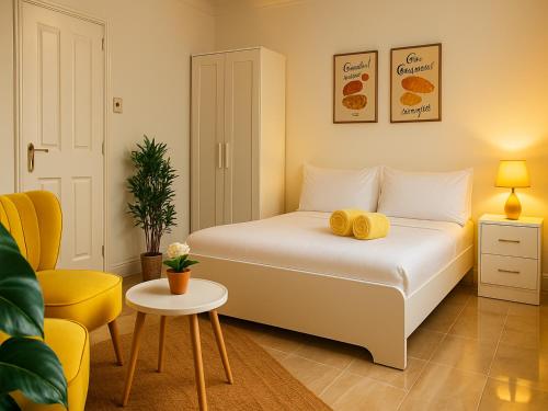 a bedroom with a bed and a yellow chair at Boutique-Style Studio Near BHX Airport & NEC in Birmingham