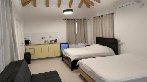 a hotel room with two beds and a kitchen at צמרת נופש in Rewaya