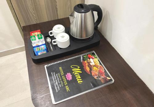 a magazine on a table with a coffee pot and a book at Hotel Lotus Arc NEAR IGI AIRPORT in New Delhi