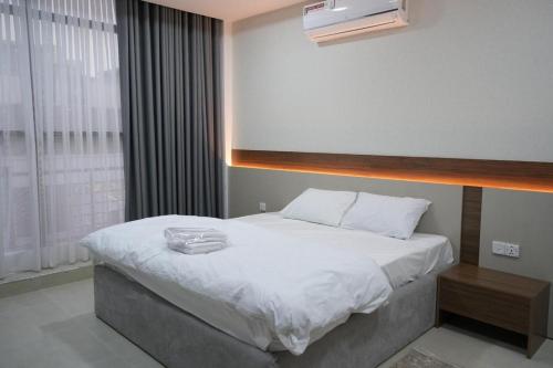 a bedroom with a large white bed and a window at Zenia Motel in Erbil