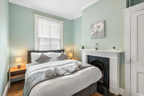 a bedroom with a large bed with a fireplace at The Quirk & Timber Retreat with Free parking in Brighton & Hove