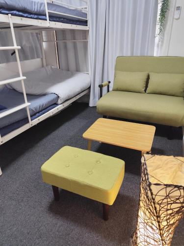 a living room with a couch and a table and bunk beds at JKhouse5 in Fukuoka