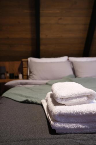 a bed with white towels on top of it at Là Guesthouses in ‘Aynţūrah