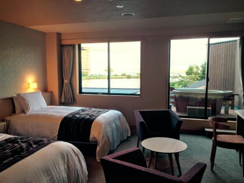 a hotel room with two beds and a window at Biwako Ryokusuitei in Otsu