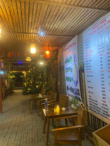 a restaurant with wooden tables and a large screen at hostel Big J in Vũ Lâm