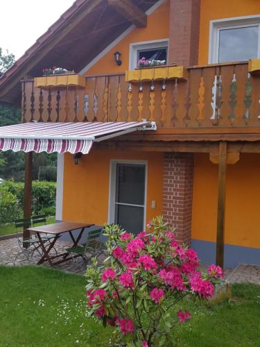 ein Haus mit einem Balkon und rosa Blumen in der Unterkunft Ferienhaus am Radweg in Brotterode