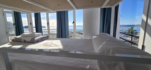 a bedroom with a bed with a view of the ocean at Albergue Club Náutico de Águilas in Águilas