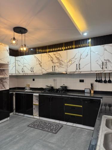 アクールにあるQuantum Havens Apartment - DUBAIの広いキッチン(白黒のカウンタートップ付)