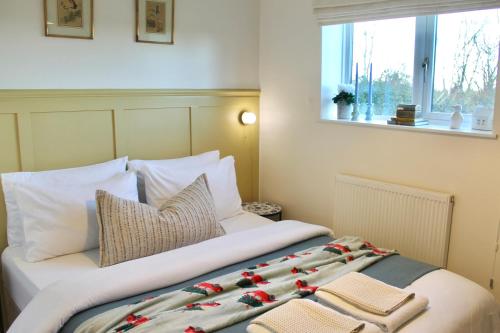 En eller flere senge i et værelse på Modern Country Cottage Stay