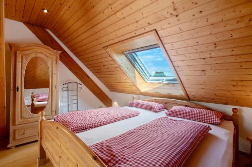 deux lits dans une chambre en bois avec une fenêtre dans l'établissement Haus Schlageter, à Dachsberg im Schwarzwald