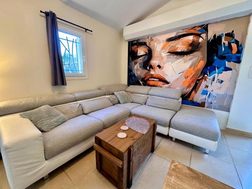 a living room with a couch and a painting at La maison des Oiseaux in Trans-en-Provence