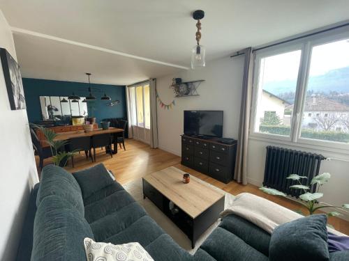 una sala de estar con un sofá y una mesa en Grand T2 lumineux et cosy - 1min Termes Marlioz, en Aix-les-Bains