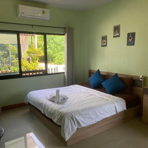 Ban Khlong Chi LatHome krabi Thailand的卧室里有一张大床，配有蓝色枕头