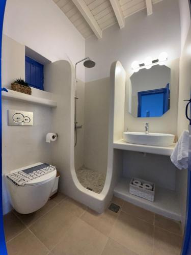 a bathroom with a toilet and a sink and a mirror at Aperanto Galazio in Koufonisia