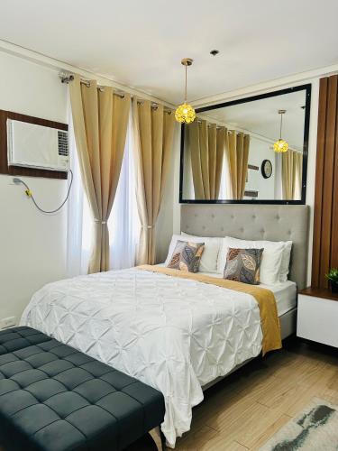a bedroom with a large bed and a mirror at Cozy Belle Suite Relaxing Place at SMDC Hope Residences in Trece Martires